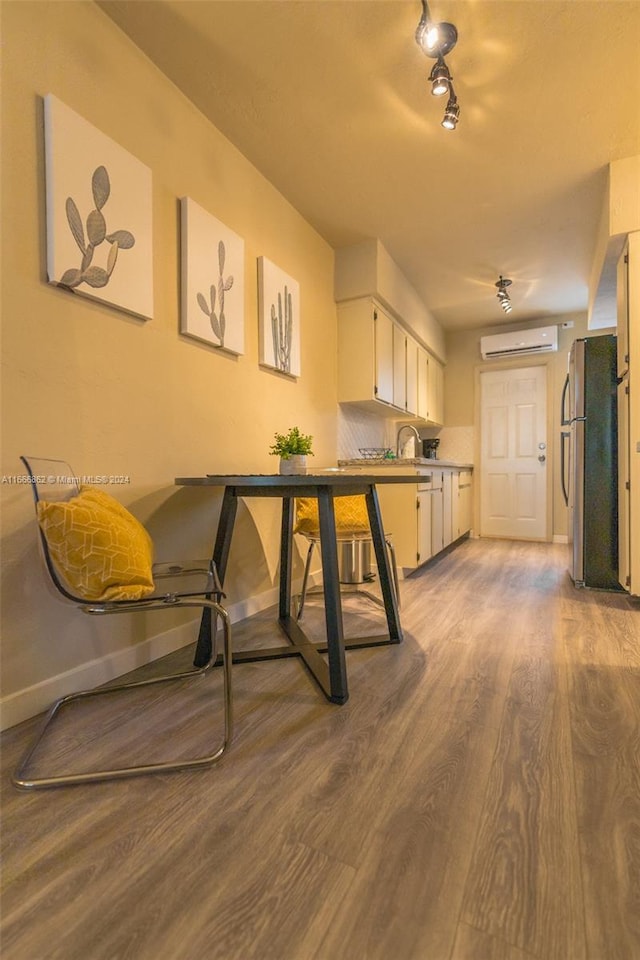 dining area featuring a wall mounted AC, hardwood / wood-style floors, and sink