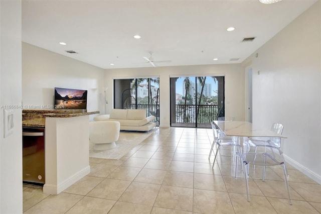 unfurnished dining area featuring ceiling fan and light tile patterned floors