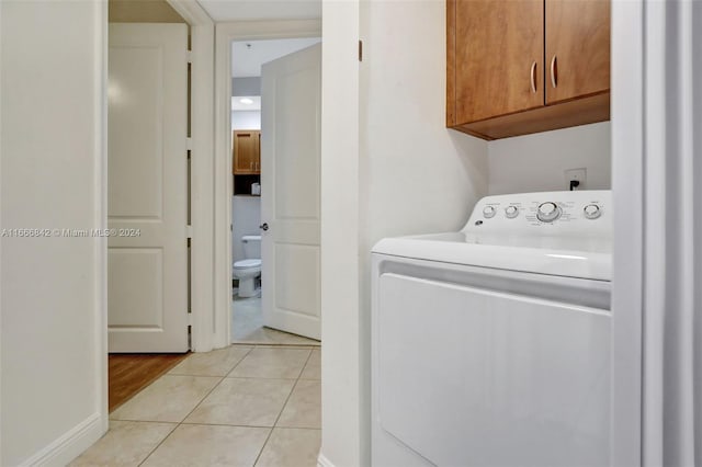 laundry room with cabinets, washer / clothes dryer, and light tile patterned floors