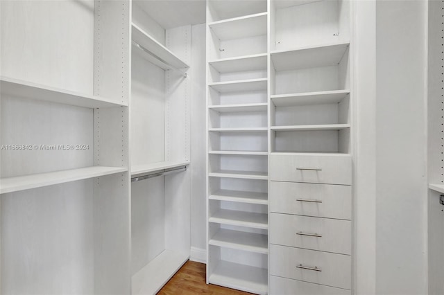 walk in closet with hardwood / wood-style floors