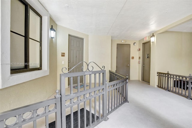 hall with a textured ceiling and concrete flooring