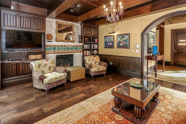 living room with wood ceiling, a tiled fireplace, beam ceiling, and dark hardwood / wood-style floors