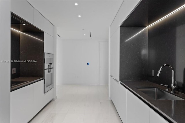 kitchen featuring sink and white cabinetry