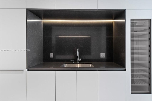 interior details with decorative backsplash, white cabinetry, wet bar, and wine cooler