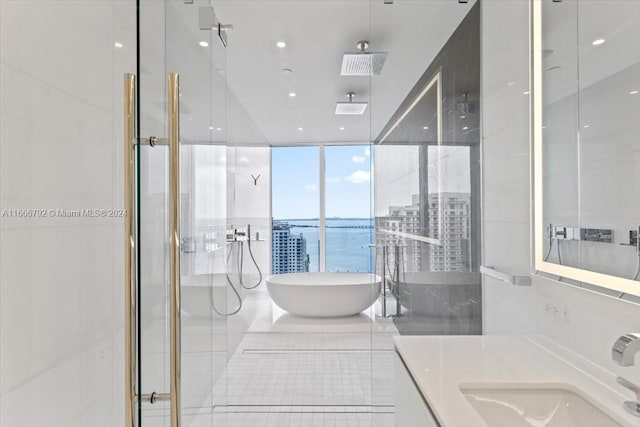 bathroom with tile walls, a water view, tile patterned floors, separate shower and tub, and vanity