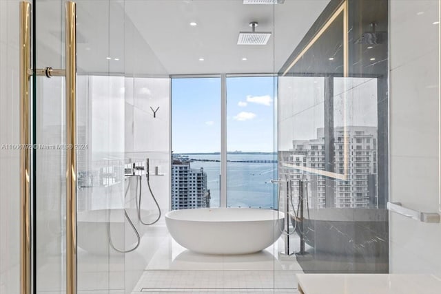 bathroom with shower with separate bathtub, a water view, tile patterned flooring, and expansive windows