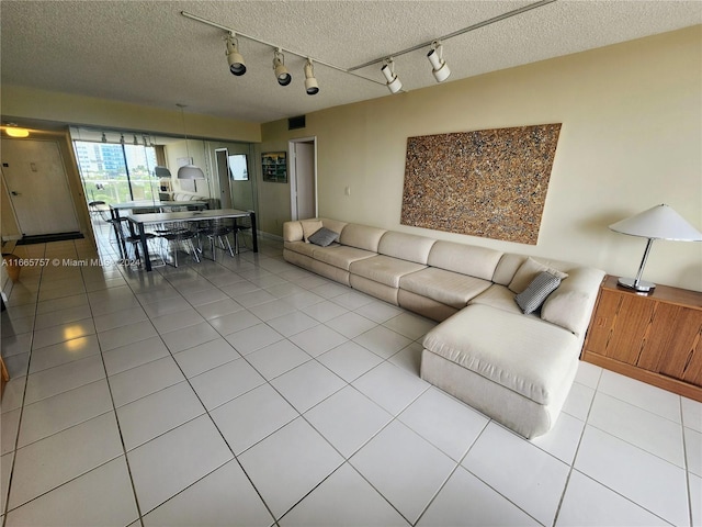 tiled living room with a textured ceiling and rail lighting