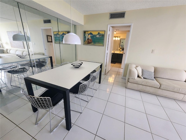 tiled dining area with a textured ceiling