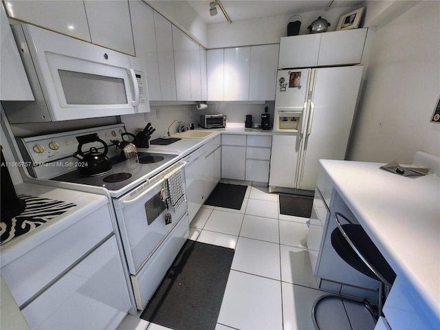 kitchen featuring white appliances, white cabinetry, sink, and light tile patterned floors