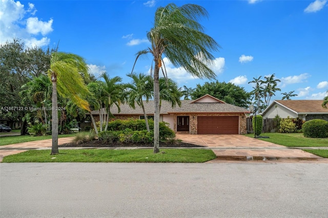 ranch-style house with a front yard and a garage