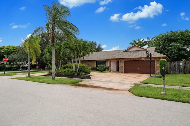 single story home featuring a garage and a front lawn