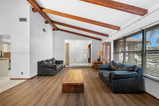 living room featuring lofted ceiling with beams and hardwood / wood-style flooring