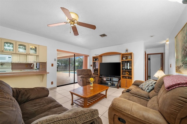 living room with ceiling fan, light tile patterned flooring, and sink