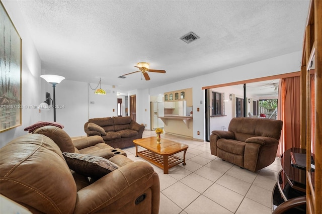 tiled living room with ceiling fan and a textured ceiling