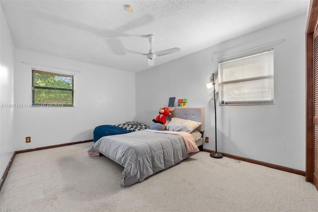 bedroom featuring a textured ceiling, ceiling fan, and light carpet