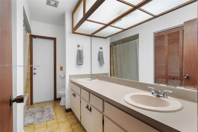 bathroom with a shower with shower curtain, tile patterned floors, vanity, and toilet