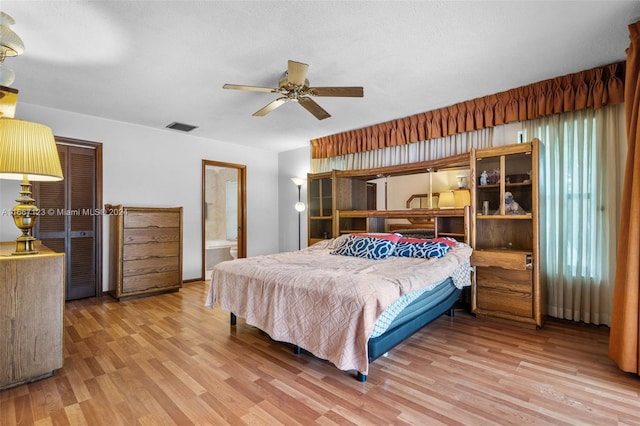 bedroom featuring wood-type flooring, a textured ceiling, connected bathroom, and ceiling fan