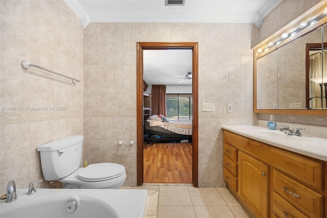 bathroom featuring tile walls, ornamental molding, toilet, and vanity