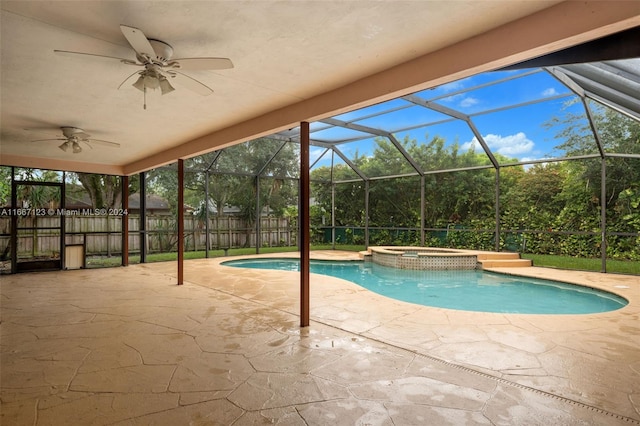 view of pool with a patio, glass enclosure, ceiling fan, and an in ground hot tub