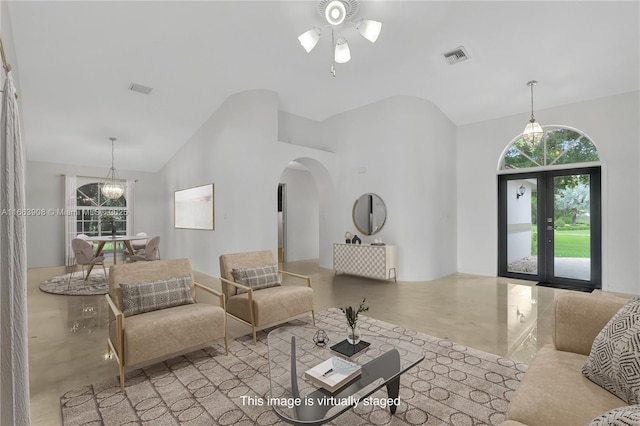 living room featuring ceiling fan with notable chandelier, high vaulted ceiling, and french doors