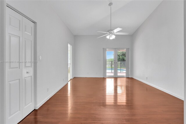 unfurnished room with ceiling fan, dark hardwood / wood-style flooring, high vaulted ceiling, and french doors