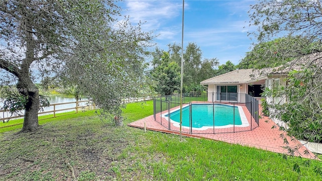 view of swimming pool featuring a yard, a water view, and a patio area