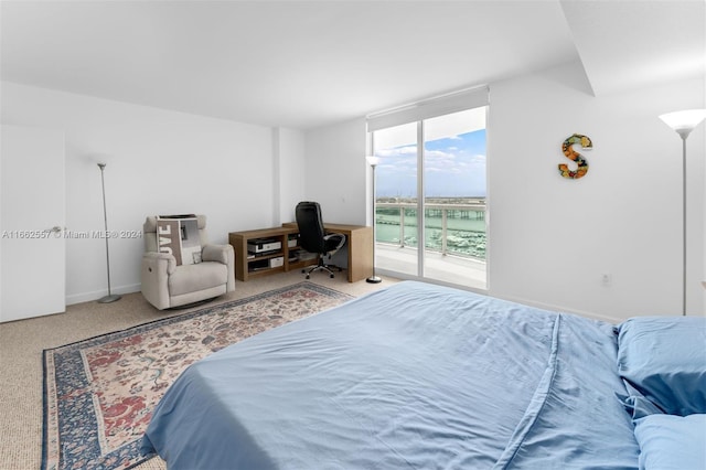 bedroom featuring carpet floors, access to exterior, and a water view