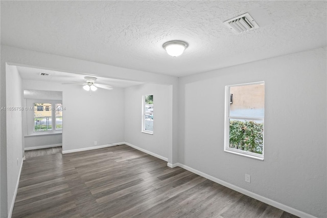 unfurnished room with a textured ceiling, dark hardwood / wood-style floors, and ceiling fan