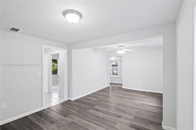 unfurnished room with a textured ceiling, ceiling fan, and hardwood / wood-style flooring