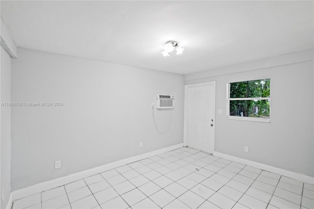 spare room featuring light tile patterned flooring and a wall mounted air conditioner