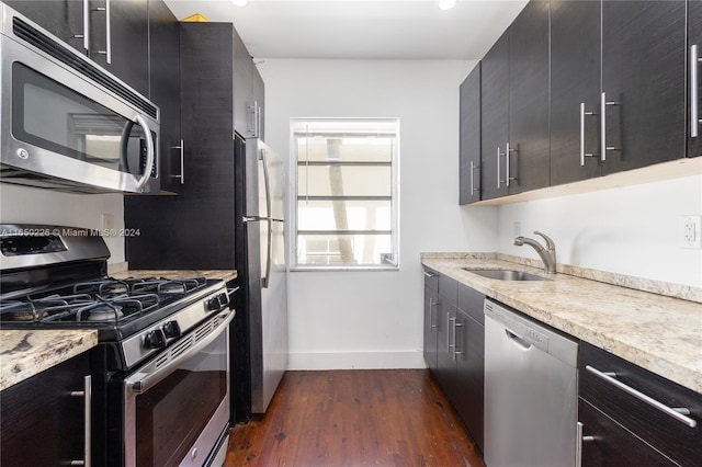 kitchen with appliances with stainless steel finishes, dark wood-type flooring, and sink