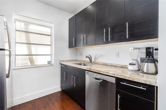 kitchen with appliances with stainless steel finishes, dark hardwood / wood-style floors, and sink