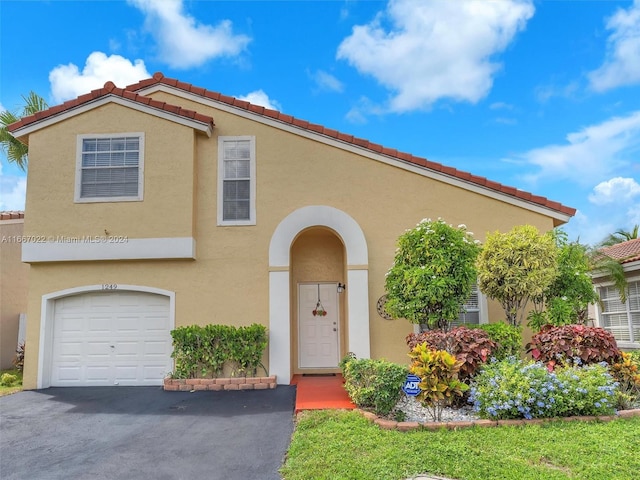 mediterranean / spanish-style home with a garage