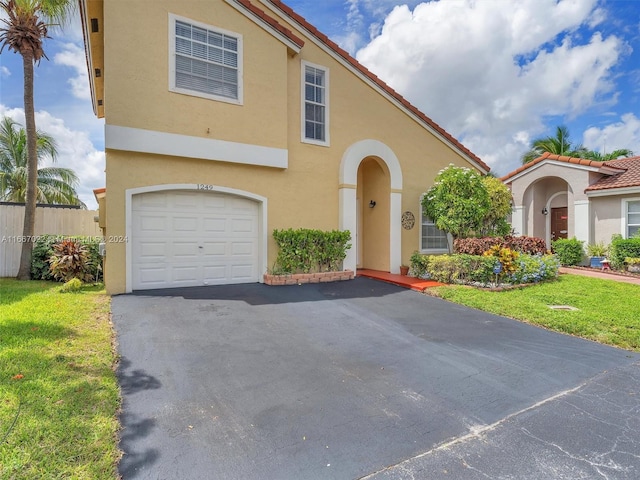 mediterranean / spanish-style home featuring a garage and a front yard