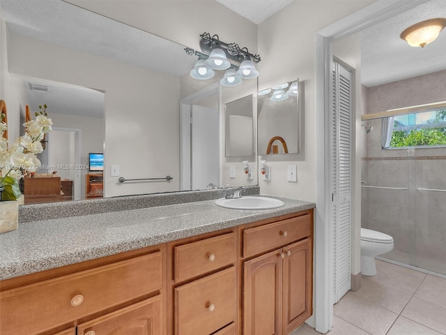 bathroom with vanity, walk in shower, a textured ceiling, tile patterned flooring, and toilet