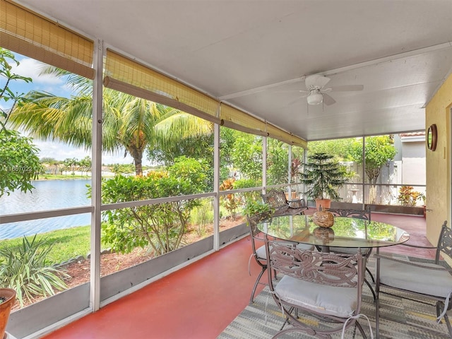 sunroom / solarium featuring a water view and ceiling fan