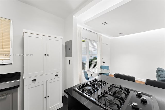 kitchen featuring white cabinets, electric panel, and stainless steel gas stovetop