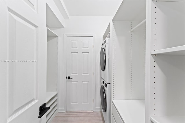 washroom featuring stacked washer and dryer and light hardwood / wood-style flooring