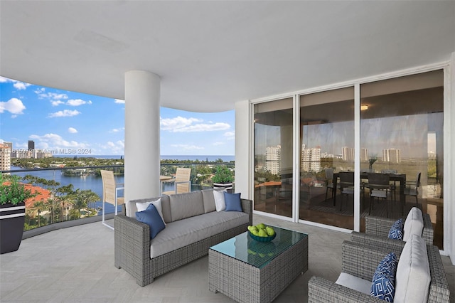 view of patio / terrace with outdoor lounge area, a balcony, and a water view