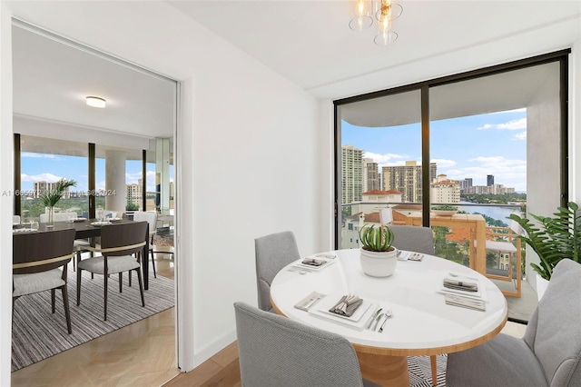 dining room featuring a water view, a notable chandelier, and light hardwood / wood-style flooring