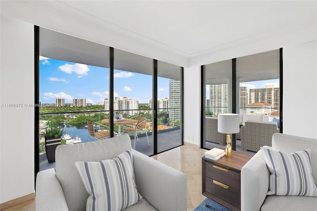 living room featuring a water view, light parquet flooring, and floor to ceiling windows