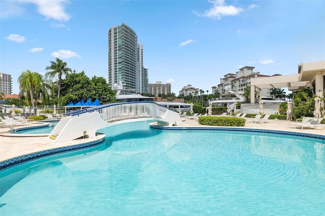 view of pool featuring a water slide and a patio area