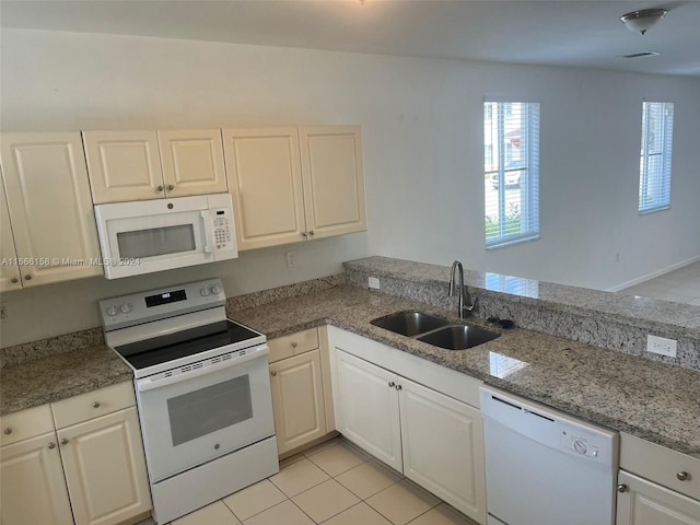 kitchen with white appliances, sink, and white cabinets