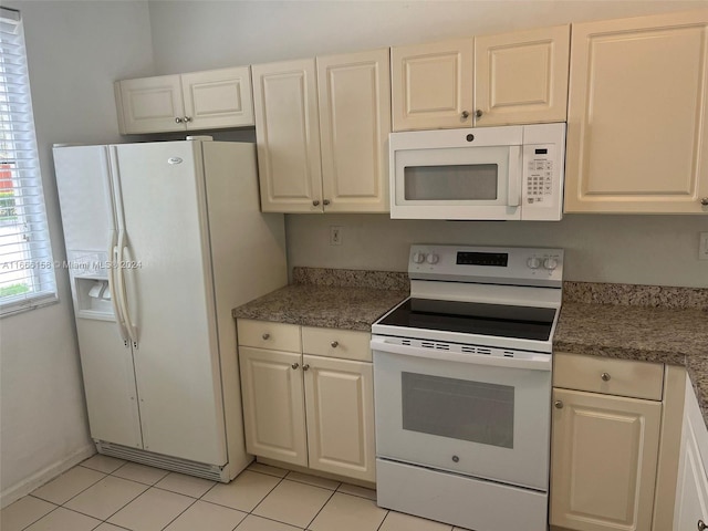 kitchen with white cabinets, light tile patterned floors, and white appliances