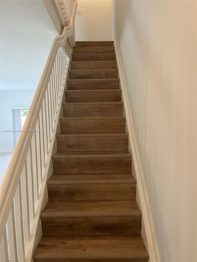 stairs featuring hardwood / wood-style floors