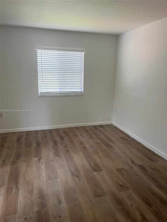 empty room with dark hardwood / wood-style flooring