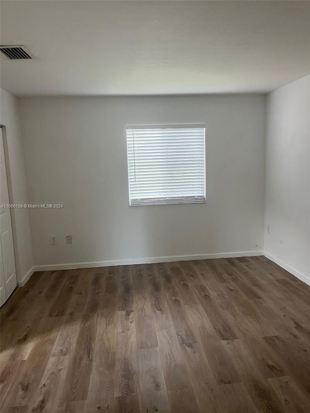 empty room with dark hardwood / wood-style flooring