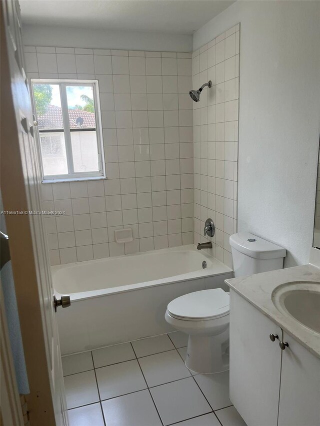 full bathroom featuring tile patterned floors, tiled shower / bath combo, vanity, and toilet