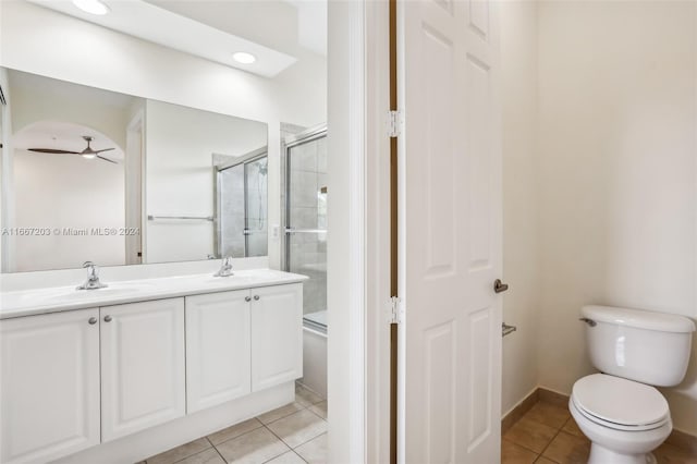 bathroom with ceiling fan, vanity, toilet, and a shower with door