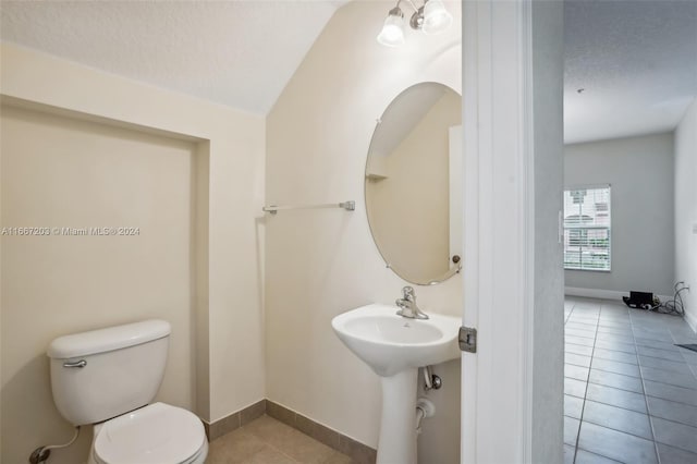 bathroom featuring a textured ceiling, toilet, and tile patterned floors